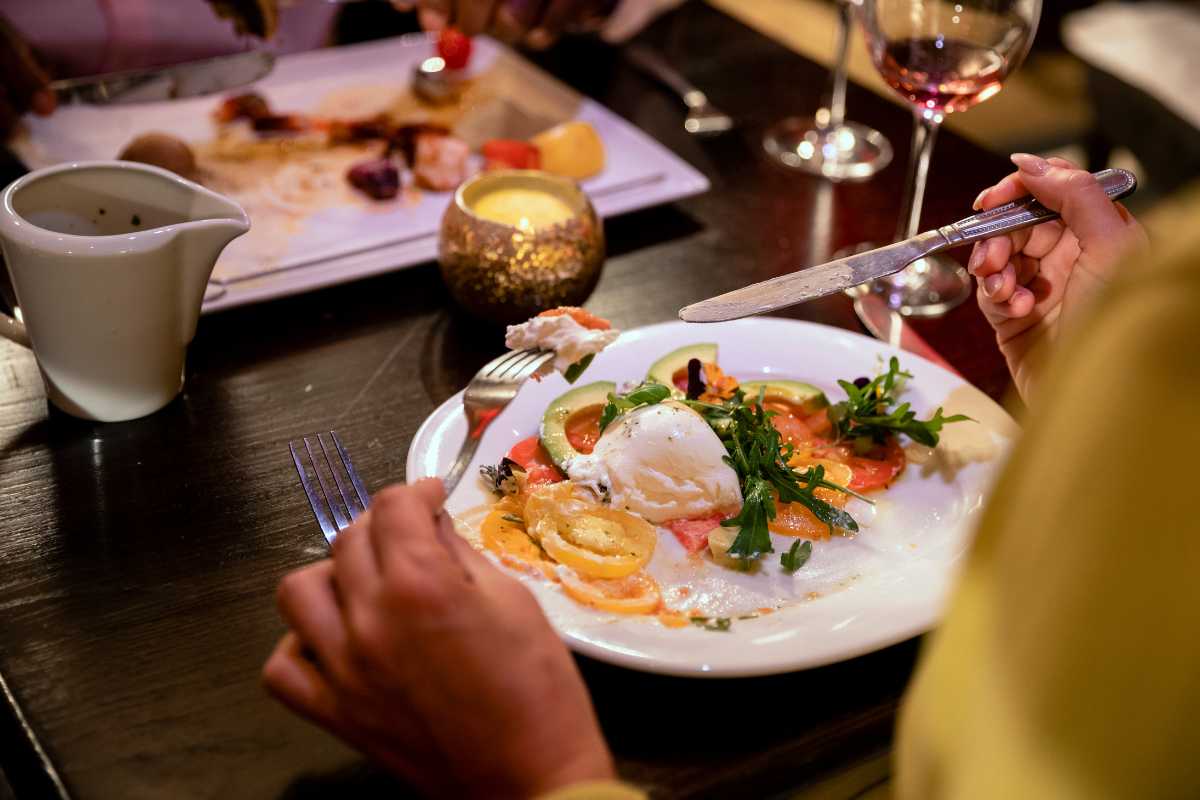 Scorcio di un ristorante tipico a Peschici, tavoli all’aperto con vista mare, profumi di pesce alla griglia, atmosfera conviviale