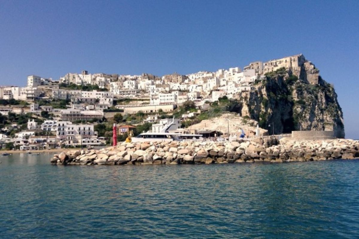 Veduta panoramica del borgo antico di Peschici con il Castello Normanno sul promontorio, cielo limpido e mare sullo sfondo