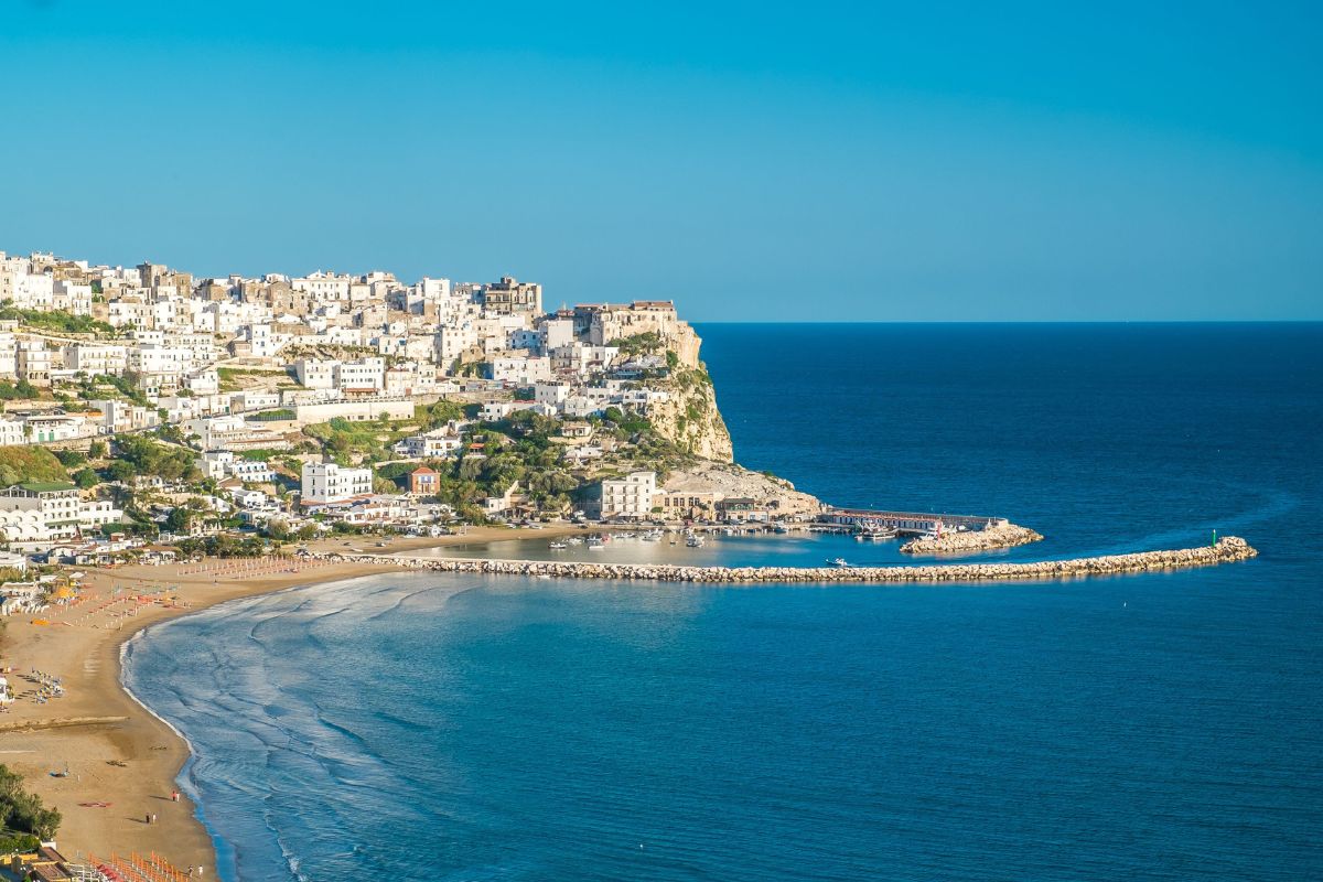 Turisti che camminano in un sentiero tra i boschi del Parco Nazionale del Gargano vicino Peschici, luce dorata, atmosfera rigogliosa